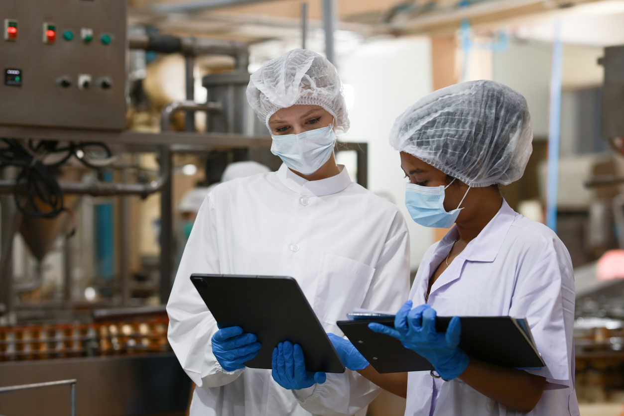 Food scientist and quality control officer Wear a hair net and sterile clothing check quality of canned fish production